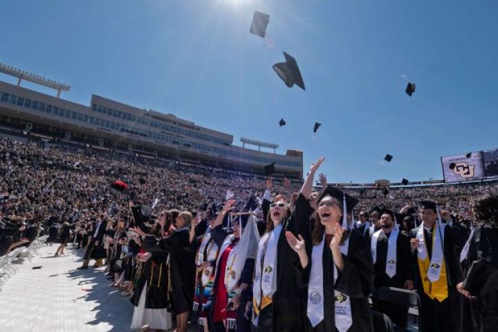 New CU graduates tossing caps in the air